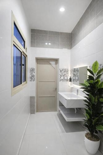 a white bathroom with a sink and a potted plant at Smo Hail سمو حائل in Hail