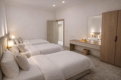 a hotel room with two beds and a mirror at Smo Hail سمو حائل in Hail