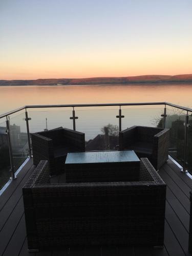 a bench on a deck with a view of the water at Thornbank House in Stranraer