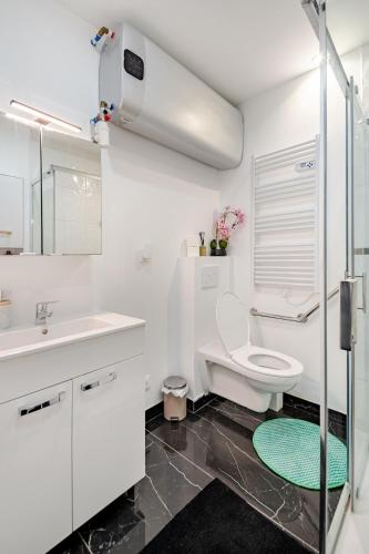 a white bathroom with a toilet and a sink at Loft design climatisé in Thiais