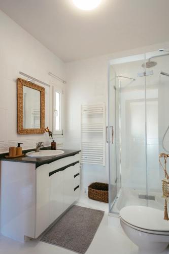 a white bathroom with a sink and a shower at Villa Maravilla in Lloret de Mar