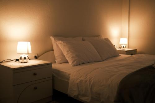 a bedroom with a bed with two lamps on it at The Sunny Side Apartment in Florina