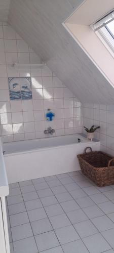 a white bath tub in a white tiled room at Vakantiewoning Zoetebeek in Oudenaarde