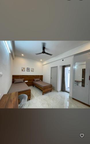 a living room with two beds and a ceiling at Sanvi studio rooms in Bangalore