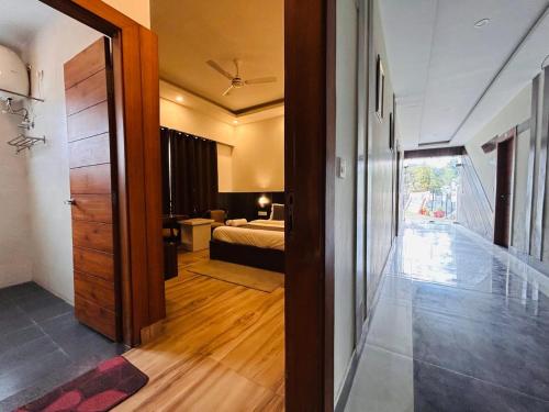 a room with a bedroom with a bed and a door at Banj View Resort in Mussoorie
