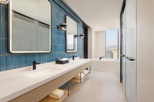a bathroom with two sinks and a mirror at Four Points by Sheraton Tianshui in Tianshui