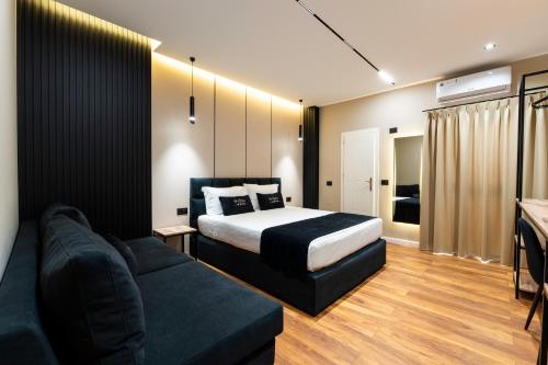 a hotel room with a bed and a couch at Bliss Boutique Hotel in Durrës