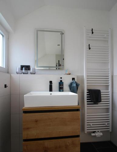 a bathroom with a white sink and a mirror at Ferienwohnung Auszeit Osterode in Osterode