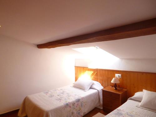 a bedroom with two beds and a light at Los campos in Hontoria