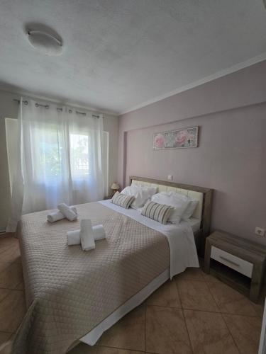 a bedroom with a large bed with two towels on it at Dimitris House Petriti in Petrití