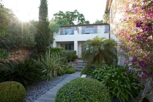 a garden in front of a white building at Le Pinarello in Sainte-Lucie de Porto-Vecchio