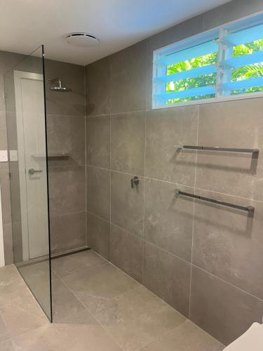 a bathroom with a shower with a glass door at Somerset Palms Studio Apartment in Horseshoe Bay