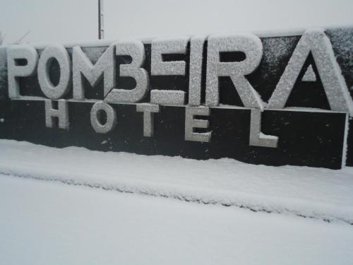 a sign on a pole with snow covered ground at Hotel Pombeira in Guarda