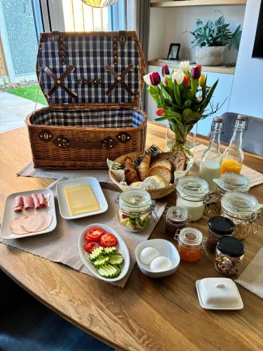 a table topped with plates of food and a basket of food at De Bakkerij appartement in Deurningen