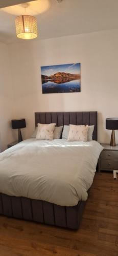 a bedroom with a large bed with white sheets at Penrith Centre Luxury 2 Bedroom Apartment with Parking in Penrith