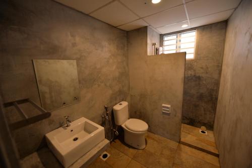 a bathroom with a white toilet and a sink at RC Cape Nautica Villas in Port Dickson