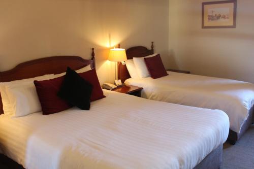 a hotel room with two beds and a lamp at Royal Valentia Hotel in Valentia Island