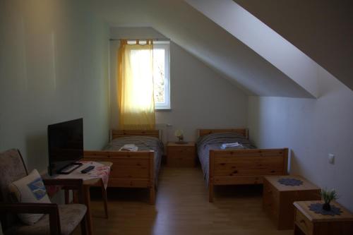 a attic room with two beds and a window at Narrenhaus in Fohnsdorf