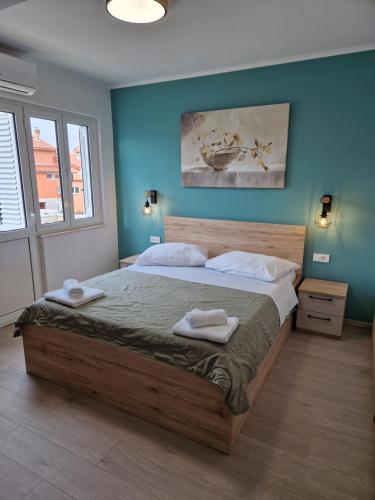 a bedroom with a large bed with two towels on it at Rooms Čapo Rab in Palit