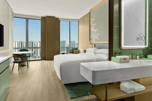 a hotel room with a bed and a bathroom with a sink at Courtyard by Marriott Yibin in Yibin