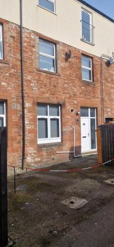 a brick building with a white door and windows at Penrith Centre Luxury 2 Bedroom Apartment with Parking in Penrith