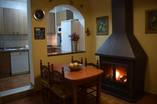 a kitchen with a table and a fireplace in a room at Apartamentos Horno y Casa De Dulce in Purullena