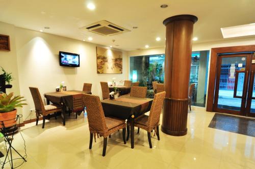 a dining room with tables and chairs and a fireplace at Baan Sukhumvit Soi 18 in Bangkok