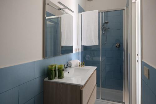 een badkamer met een wastafel en een douche met een spiegel bij Villa Coccodrilla in Toscolano Maderno