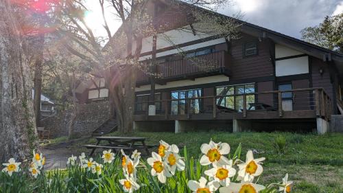a house with flowers in front of it at Tanigawa Valley Lodge & Coffee Roastery in Minakami