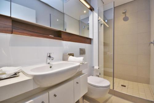 een witte badkamer met een wastafel en een toilet bij 418 Zimbali Suites in Ballito