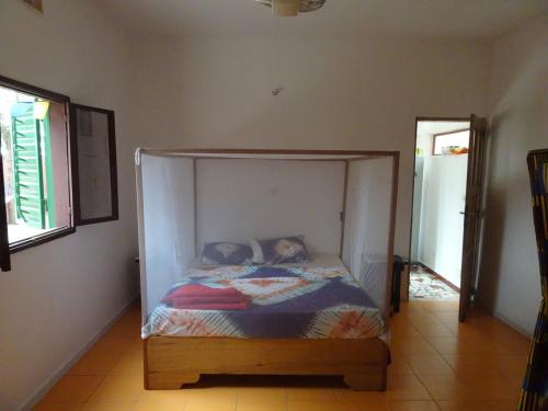 a bed with a canopy in a room at Oasis Palmarin in Palmarin