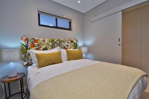 een slaapkamer met een groot bed met gele kussens bij 418 Zimbali Suites in Ballito