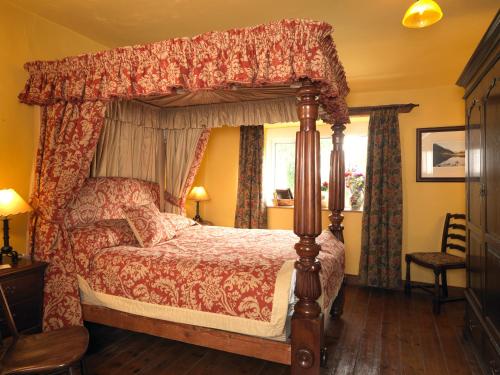 una camera da letto con letto a baldacchino e finestra di Summerhill Cottage a Windermere