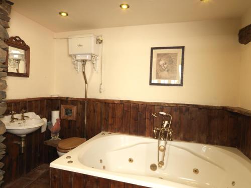 un bagno con vasca e lavandino di Summerhill Cottage a Windermere
