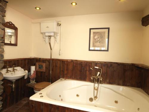 La salle de bains est pourvue d'une baignoire et d'un lavabo. dans l'établissement Summerhill Cottage, à Windermere