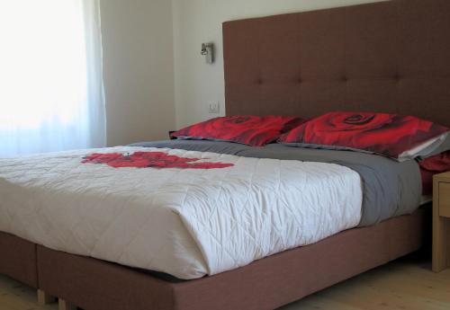 a large bed with red flowers on it in a bedroom at Villa delle Querce in Tremosine Sul Garda
