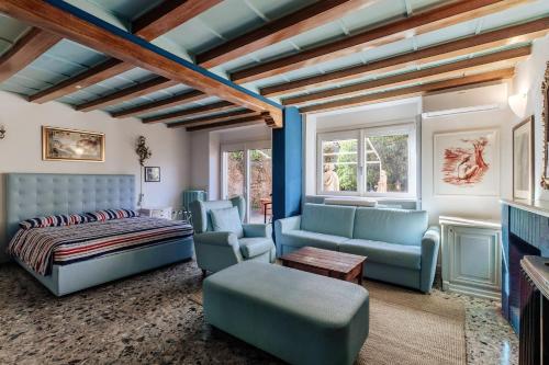 a living room with blue furniture and a bed at Bellagio Bed & Breakfast in Bellagio