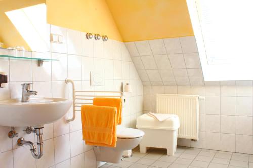 a white bathroom with a sink and a toilet at Kessenbrock Appartements in Witten