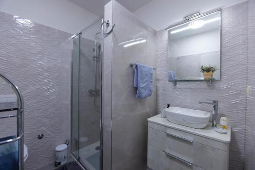 a white bathroom with a sink and a shower at Emma in Krasica