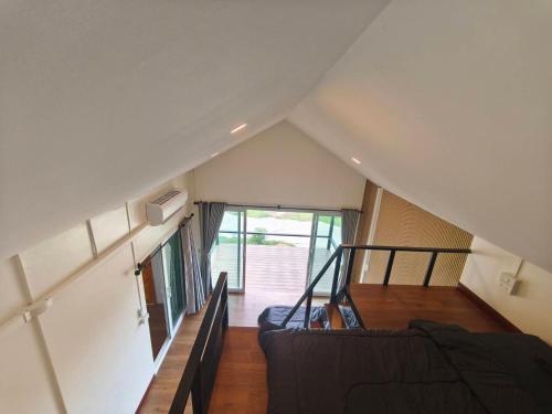 a attic room with a couch and a staircase at Wangpocamping วังโพแค้มป์ปิ้ง in Ban Wang Pho