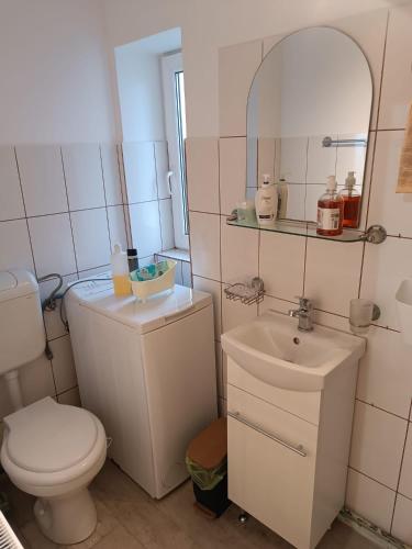 a white bathroom with a toilet and a sink at Casa ANDA in Braşov