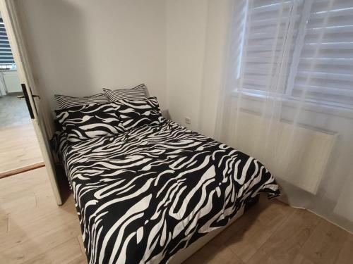 a black and white bed in a room with a window at Casa ANDA in Braşov