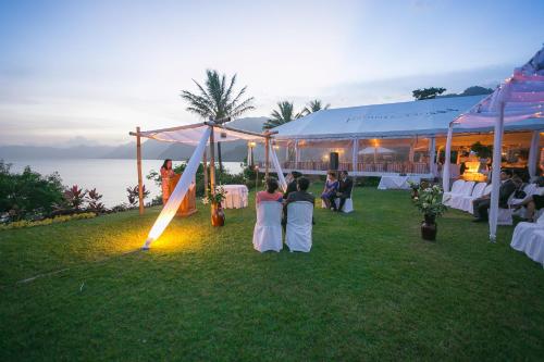 een groep mensen die voor een tent zitten bij Hotel y Centro de Convenciones Jardines del Lago in Panajachel