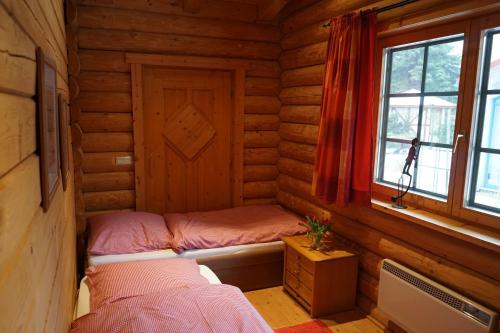 a small room with a bed in a log cabin at Blockhaus Fleesensee in Silz
