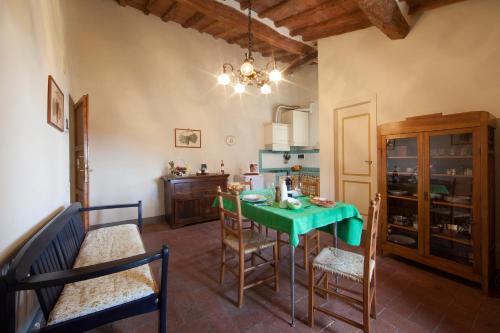 a dining room with a green table and chairs at Fattoria Poggio Capponi in Montespertoli