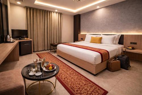 a hotel room with a large bed and a television at OPO Horizon Aerocity ,Delhi Airport in Jāmb