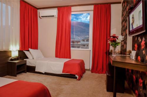 a bedroom with a bed and a window with red curtains at Central Guest Rooms in Asenovgrad