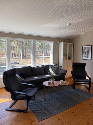 a living room with a couch and two chairs and a table at Semesterhus nära Köpingsvik in Köpingsvik