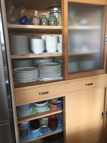 a cabinet filled with plates and bowls at Kagura House in Yuzawa