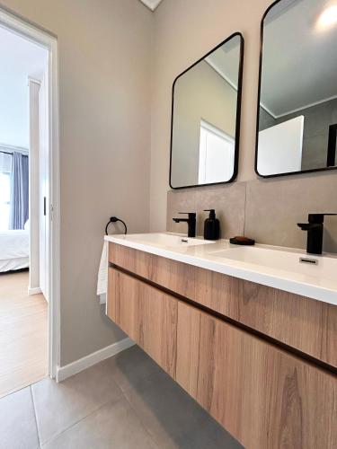 a bathroom with a sink and two mirrors at 95 Yang Suite A in Johannesburg